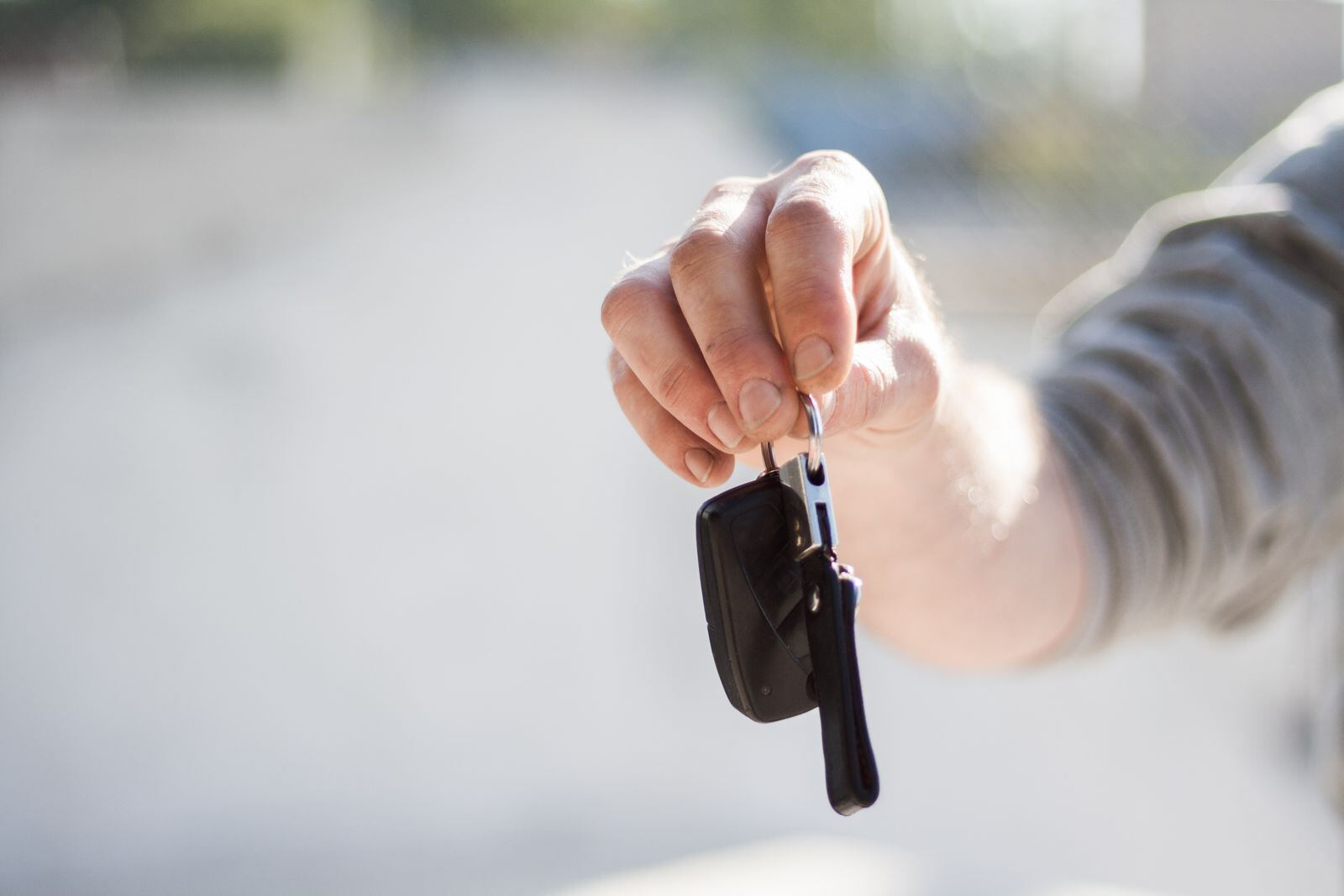 Hand holding out a car key